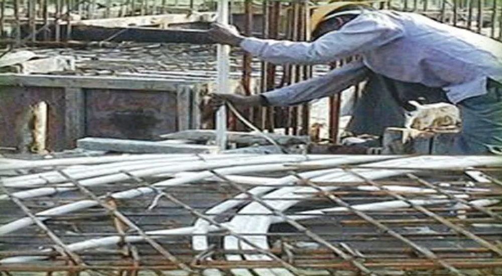 White Kamalplast conduit pipes laid over steel reinforcement on a building site